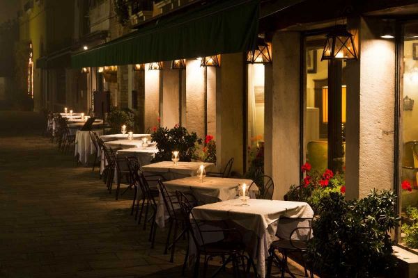 Italy, Venice Restaurant tables lit at night